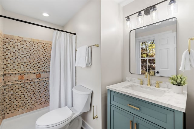 bathroom featuring tiled shower, toilet, and vanity