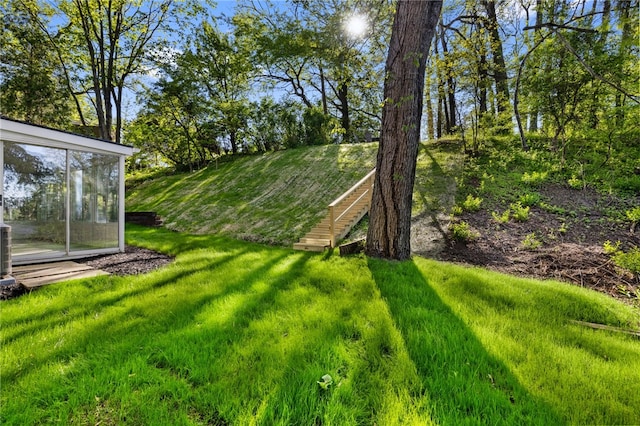 view of grassy yard featuring a sunroom