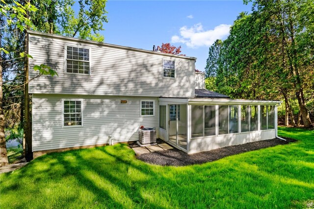 back of house featuring a sunroom, central air condition unit, and a yard