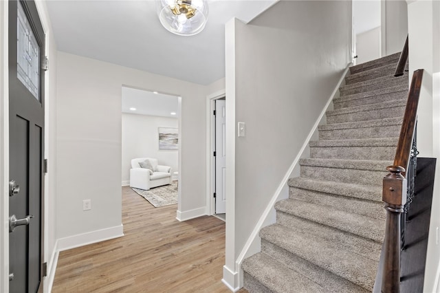 foyer entrance with stairs, light wood-type flooring, baseboards, and recessed lighting