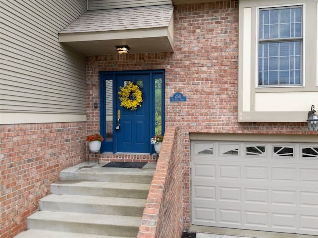 property entrance with brick siding and an attached garage