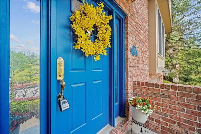view of exterior entry with brick siding