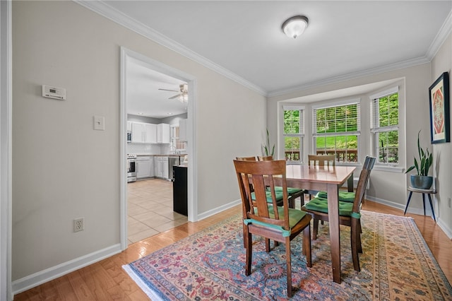 dining area featuring crown molding, baseboards, light wood-style floors, and a ceiling fan