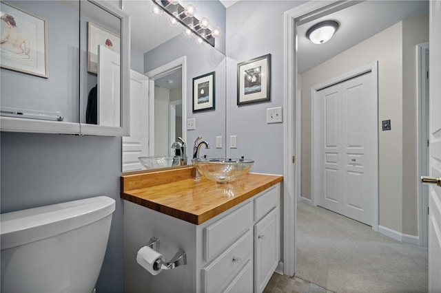 bathroom featuring vanity, toilet, and baseboards