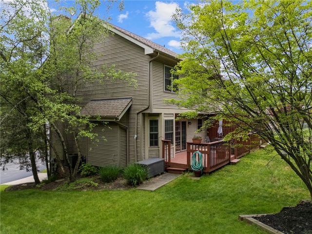 back of house featuring a deck, a chimney, and a yard