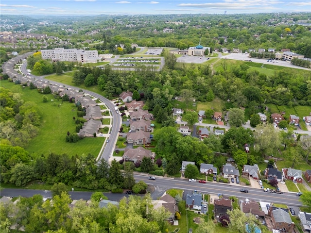 view of property location featuring nearby suburban area and a tree filled landscape