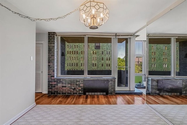 sunroom / solarium featuring a chandelier