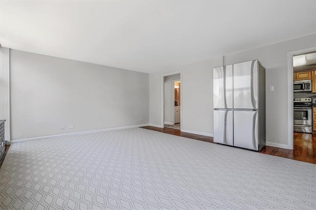 unfurnished living room featuring dark wood-style floors and baseboards