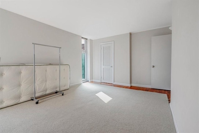 carpeted spare room featuring baseboards