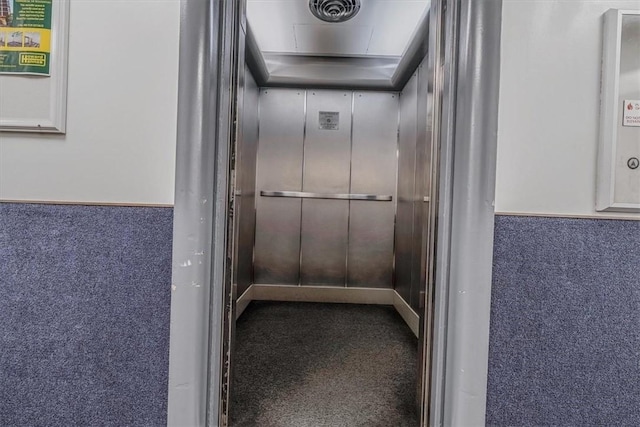 corridor with carpet and elevator