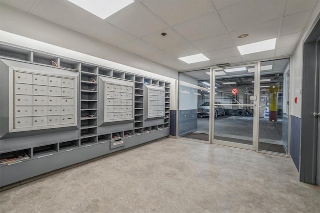 view of property's community featuring mail area and a drop ceiling