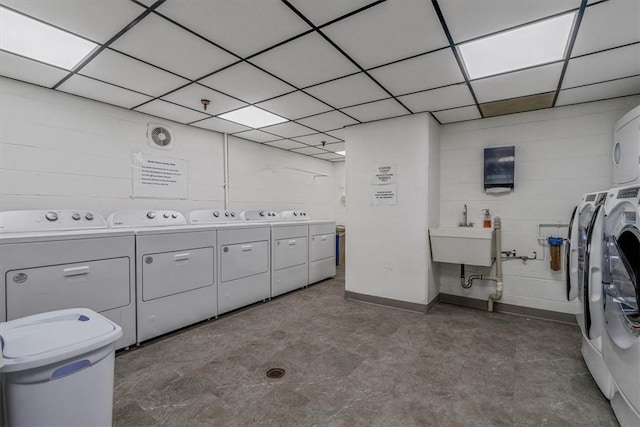 shared laundry room with separate washer and dryer and concrete block wall