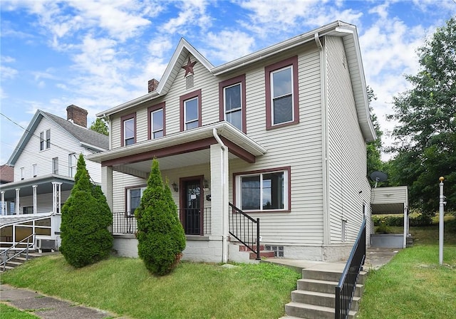 view of front of home featuring a front lawn, a chimney, and covered porch