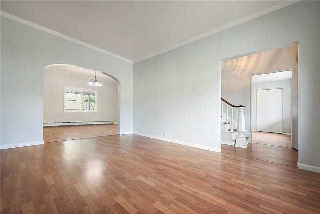 empty room featuring baseboard heating, arched walkways, crown molding, wood finished floors, and a chandelier