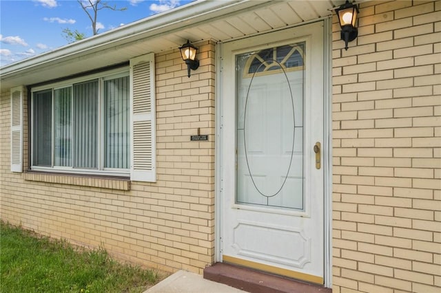 doorway to property featuring brick siding