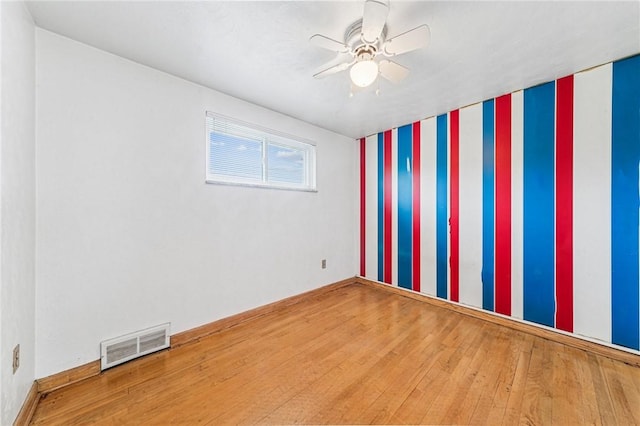 empty room with wood finished floors and a ceiling fan