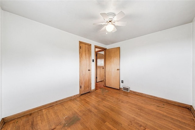 empty room with baseboards, light wood finished floors, and ceiling fan