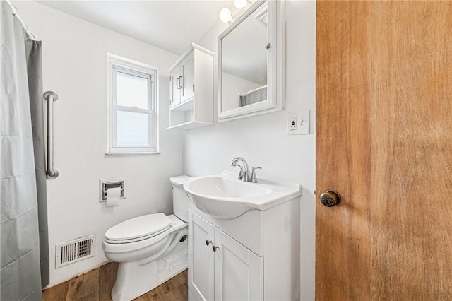 bathroom with wood finished floors, vanity, and toilet