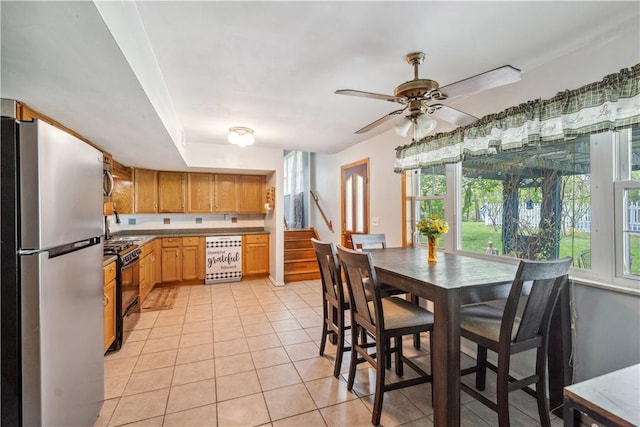 106 Boyanna Dr, Industry, PA 15052 - kitchen featuring freestanding refrigerator, black gas range oven, light tile patterned floors, ceiling fan, and a sink