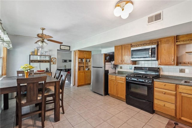 106 Boyanna Dr, Industry, PA 15052 - kitchen with appliances with stainless steel finishes, dark countertops, decorative backsplash, and ceiling fan