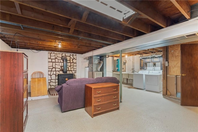 basement with separate washer and dryer, a wood stove, and heating unit