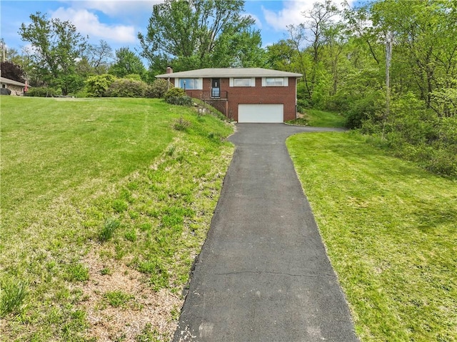 view of front facade featuring brick siding, a garage, driveway, and a front lawn