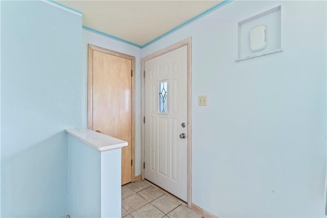 foyer entrance featuring light tile patterned flooring and baseboards
