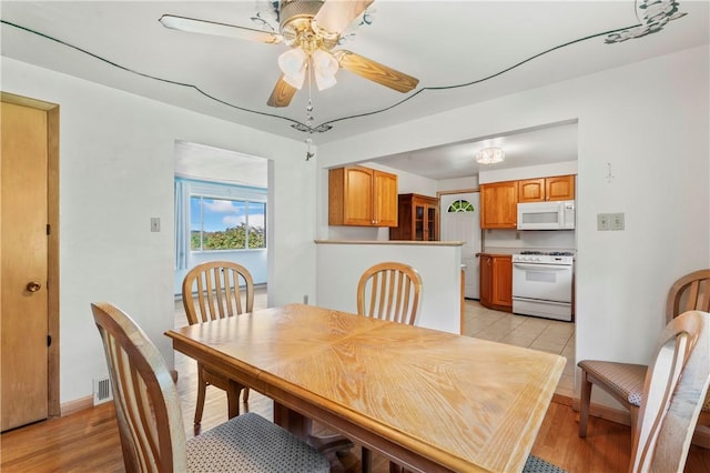 dining room featuring a ceiling fan and light wood-style floors