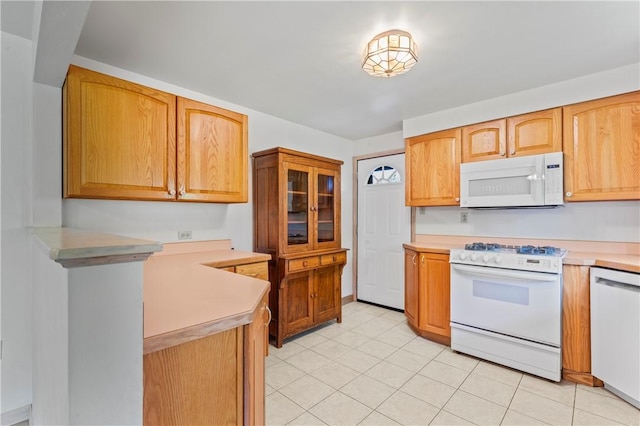 kitchen featuring white appliances, light countertops, and light tile patterned flooring