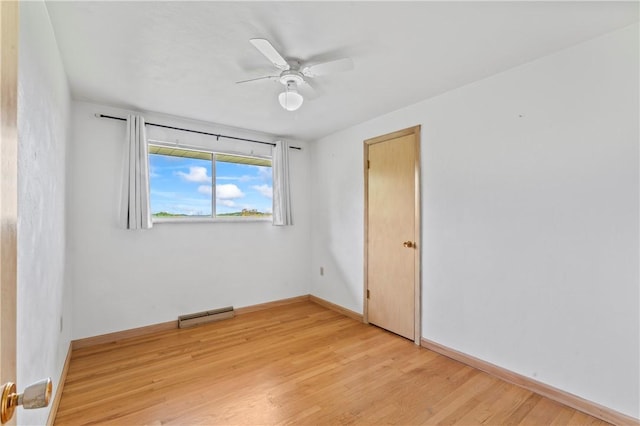 unfurnished room with light wood finished floors, a ceiling fan, and baseboards