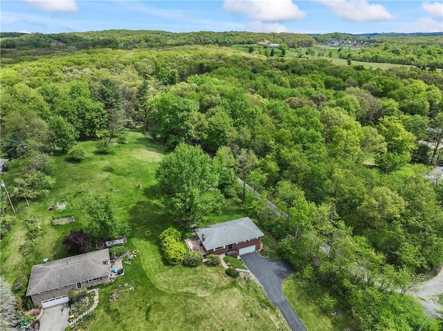 aerial view of property and surrounding area featuring a forest