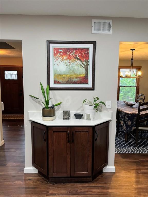 1016 Timberwood Ct, Murrysville, PA 15668 - bar with dark wood-style flooring, a chandelier, and baseboards