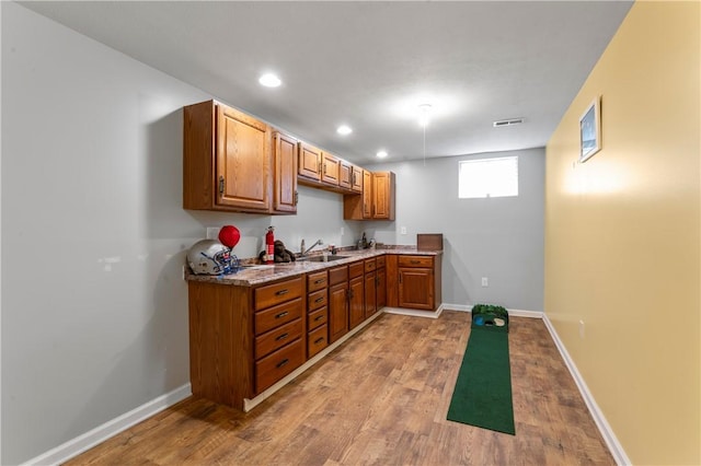 bar with a sink, wood finished floors, recessed lighting, and baseboards