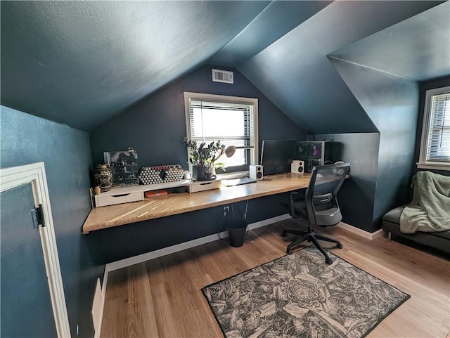 office area featuring wood finished floors, vaulted ceiling, and baseboards