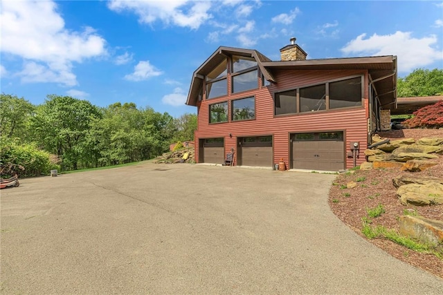 584 Park Rd, Chippewa Twp, PA 15010 - view of front of home featuring a garage, asphalt driveway, and a chimney