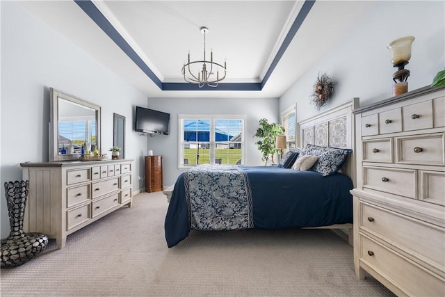 bedroom with a chandelier, light colored carpet, and a tray ceiling