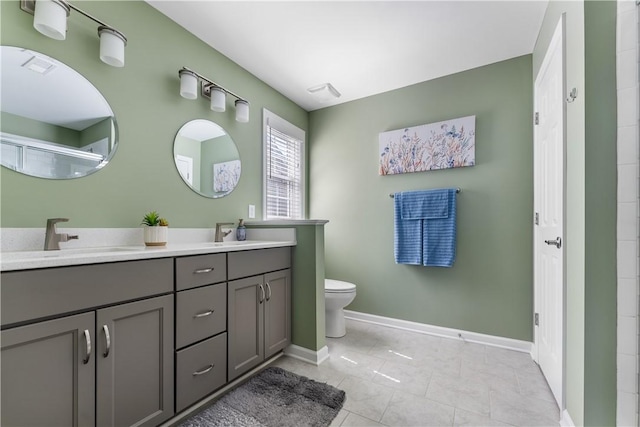 bathroom featuring double vanity, toilet, baseboards, a shower, and tile patterned flooring
