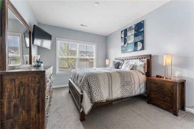 bedroom featuring light colored carpet and baseboards