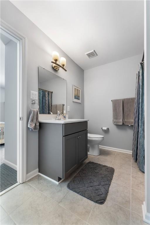 full bath with toilet, vanity, tile patterned flooring, and baseboards
