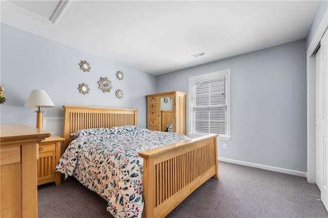 bedroom with dark colored carpet, a closet, and baseboards
