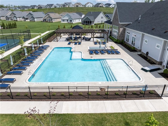 community pool with a pergola, a patio, and a residential view