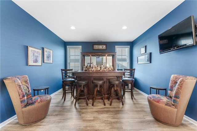 indoor dry bar featuring baseboards, wood finished floors, and recessed lighting