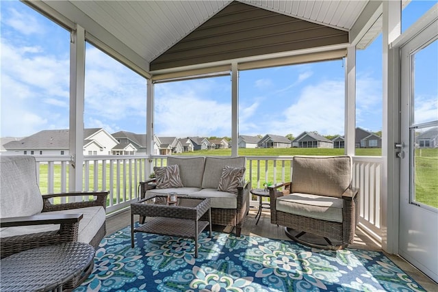 sunroom / solarium featuring a residential view, vaulted ceiling, and an outdoor hangout area