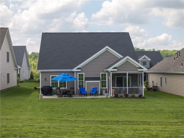 rear view of house featuring a lawn, a patio, and a shingled roof