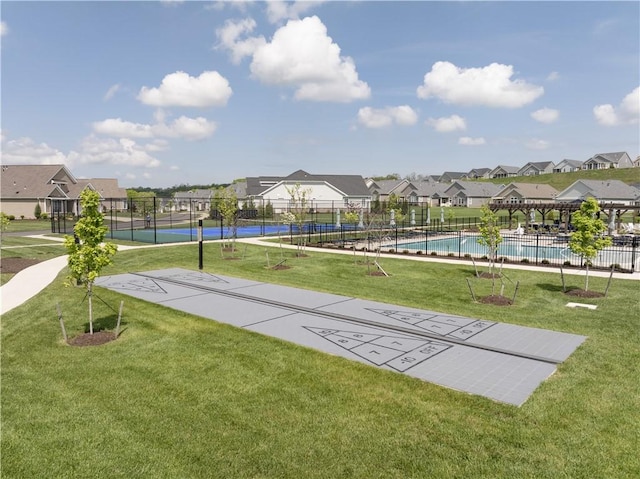 surrounding community with shuffleboard, a residential view, and a swimming pool