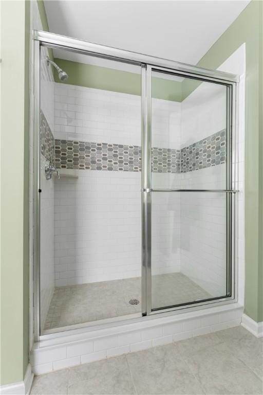 full bath featuring a shower stall, baseboards, and tile patterned flooring