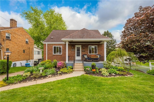 view of front of home with covered porch, brick siding, and roof with shingles