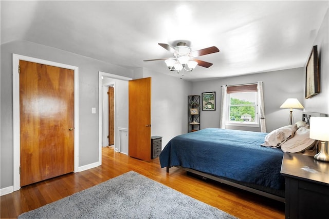 bedroom featuring wood finished floors, a ceiling fan, and baseboards