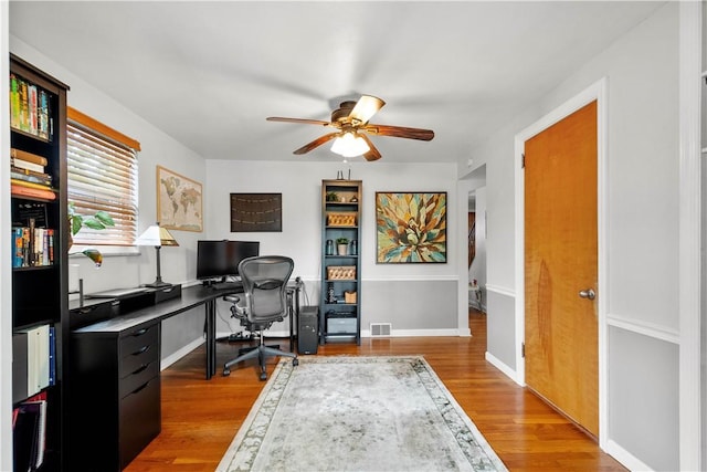 office space with ceiling fan, wood finished floors, and baseboards