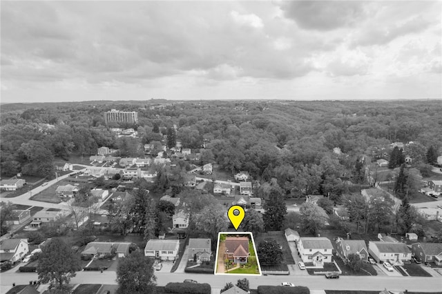 aerial view of residential area with property parcel outlined and a heavily wooded area